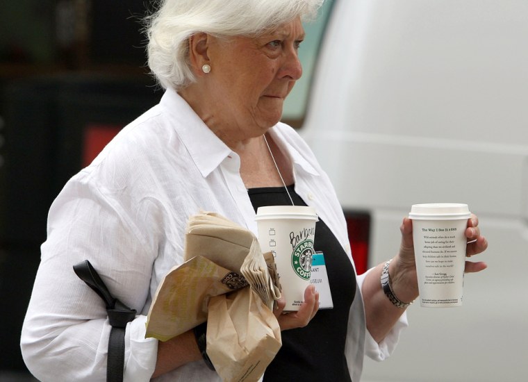 Image: A Starbucks customer carries drinks as she leaves a Starbucks store
