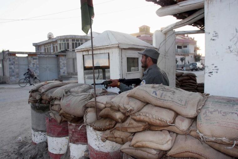 Image: An Afghan policeman keeps guard in front of the office of  Asian Rural Life Development Foundation.