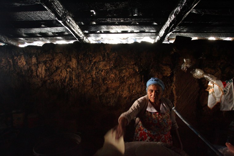 Image: A woman waits for tortillas to heat