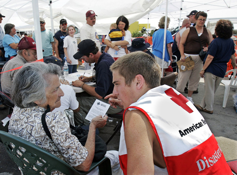 Image: A woman is helped by a Red Cross worker P at a counseling tent set up by the Red Cross in Bay St. Louis, Miss. after hurricane Katrina.