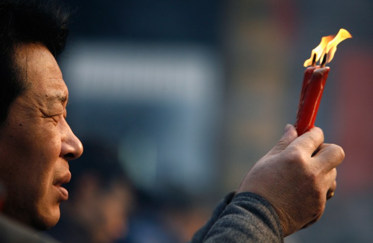 Image: Buddhist prays during temple fair for New Lunar Year in Shanghai
