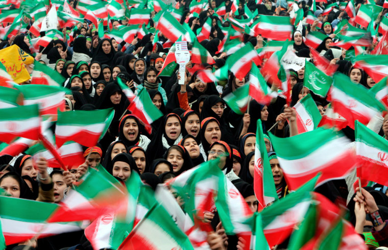 Image: Iranian female students wave national flags.