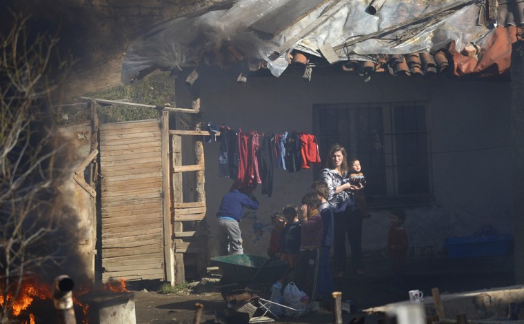 Image: A Kosovar woman and her children watch the fire set to burnout their garbage.