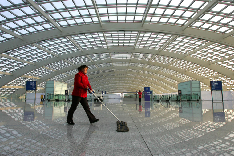 A worker cleans at the high speed rail terminal at the new Terminal 3 building at Beijing Airport Tuesday Feb. 26, 2008. The terminal, which opens Friday, is a centerpiece project for the 2008 Olympics and is designed to relieve the overloaded airport's other two terminals and accommodate expected rapid growth in the number of visitors to Beijing. The huge, airy terminal will have 64 Western and Chinese restaurants, 84 retail shops, and a state-of-the-art-baggage handling system. Six airlines will begin flying into the terminal Friday, while others will switch over in March. (AP Photo/Greg Baker)