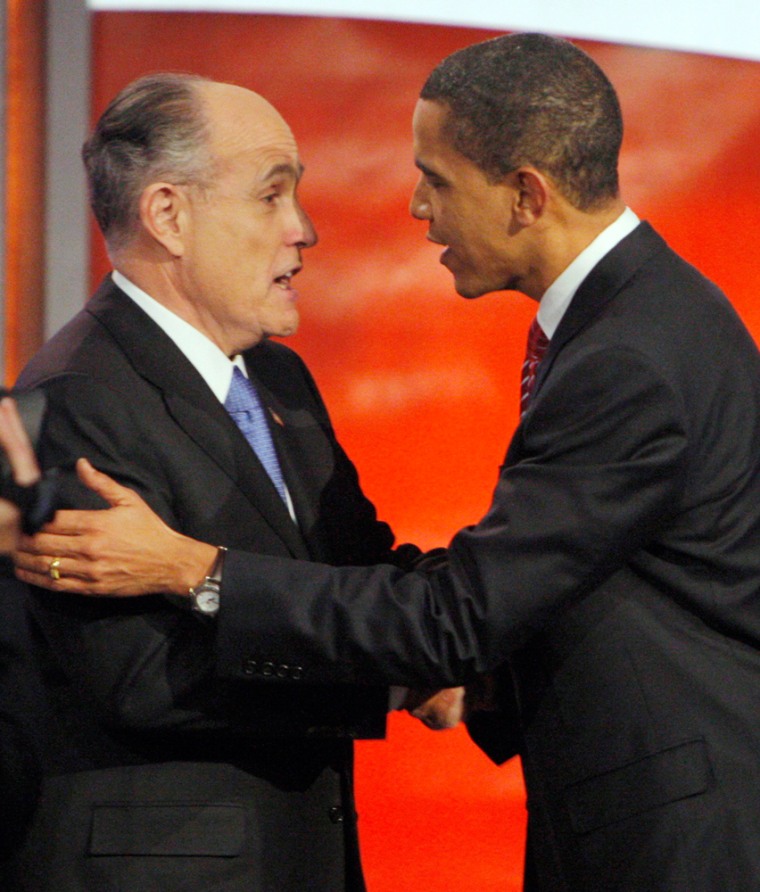 Image: U.S. Presidential candidates Giuliani and Obama talk on stage between debates in Manchester