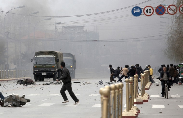 Image: Tibetans throw stones at army vehicles.