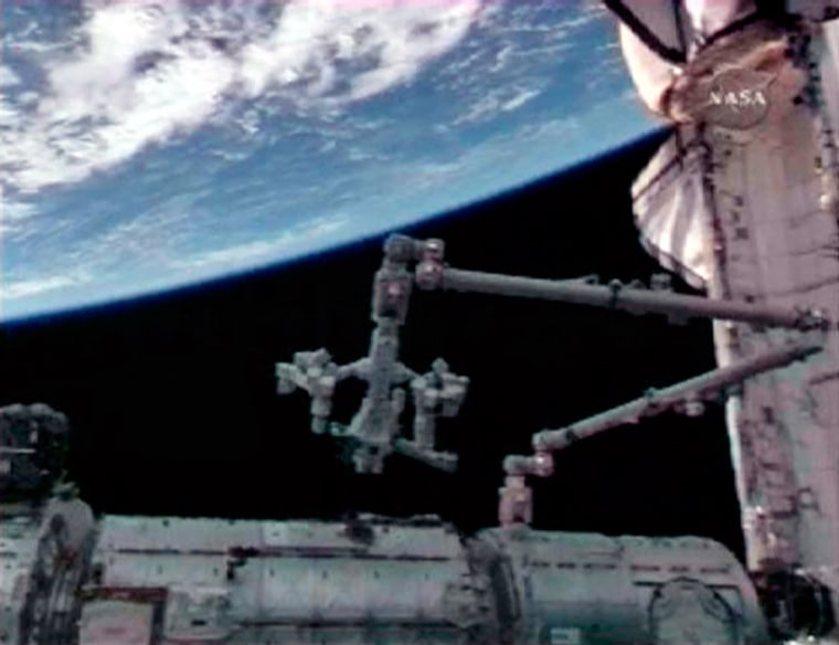 Image: The crew aboard the International Space Station uses the Canada Arm2 to moves the Canadian Space Agency's two-armed robotic system Dextre to the Destiny module.