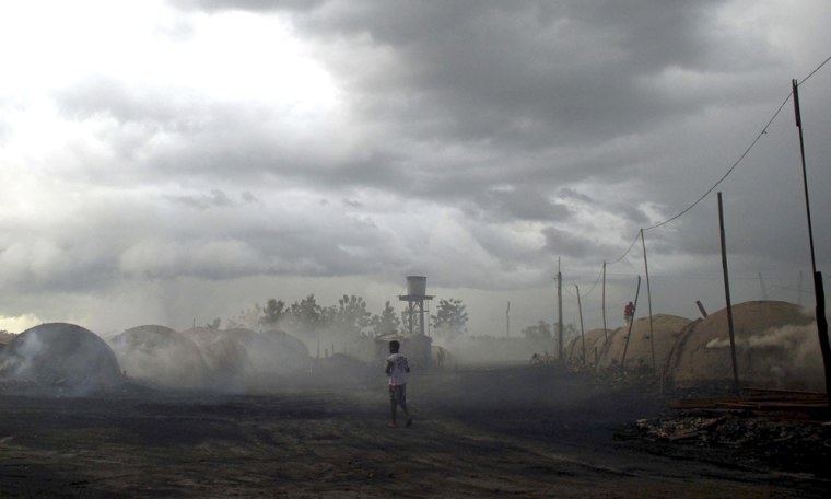 Image: A man walks past charcoal kilns in Tailandia, state of Para, Brazil