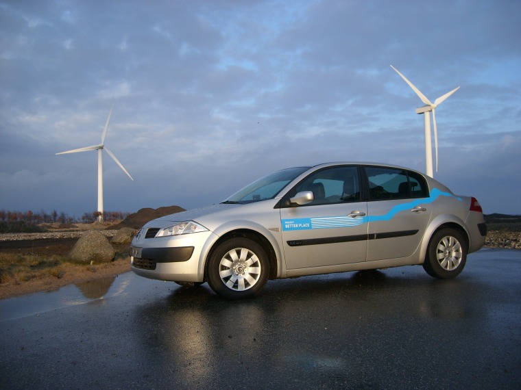 Project Better Place positioned its prototype electric vehicle next to these wind turbines in Denmark as it unveiled plans for a wind-powered network on Thursday.