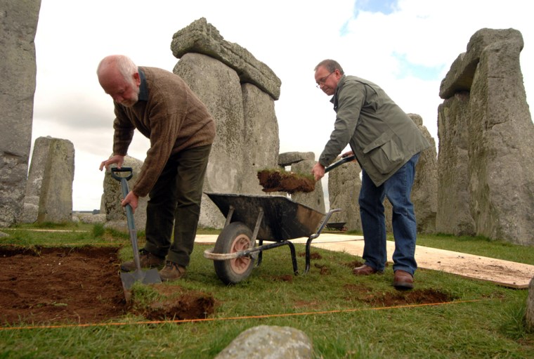 Image: Professor Tim Davill and Professor Geoff Wainwright from Bournemouth University digging turf within the circle of Stonehenge
