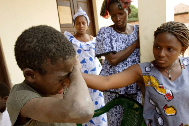 **ADVANCE FOR MONDAY, APRIL 21** Coli, a former religious student who fled the Quranic teacher that forced him to beg on the streets of Dakar, Senegal, cries as female relatives arrive to meet him at a temporary shelter in Gabu, Guinea-Bissau, Monday, Dec. 17, 2007. The overwhelming majority of Dakar's child beggars are sent out to beg under the cover of Islam, placing the problem at the complicated intersection of greed and tradition. Over the past two years, the International Organization for Migration has rescued 600 child beggars from Senegal and brought them home to their families in neighboring countries and Senegal's poor, rural interior. (AP Photo/Rebecca Blackwell)