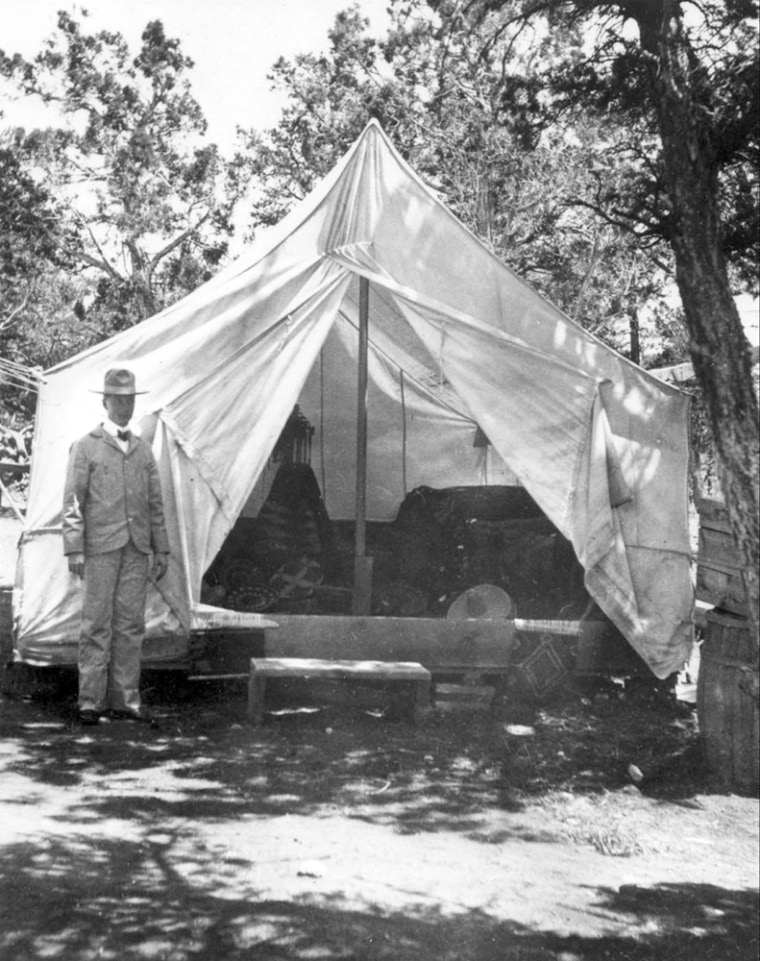 Image:John George Verkamp stands by his tent .