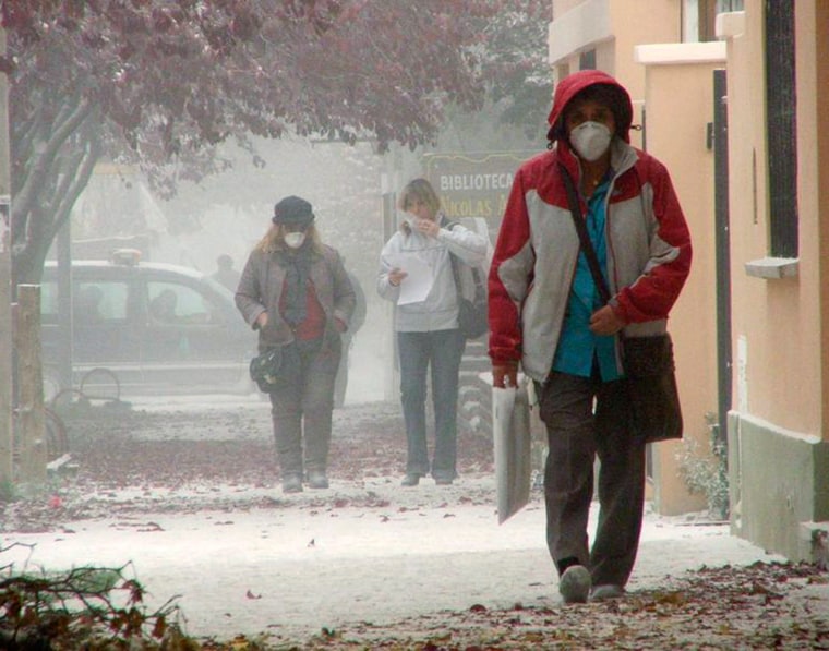 Image: Residents wearing surgical facemasks walk in Argentina's Patagonian city of Esquel