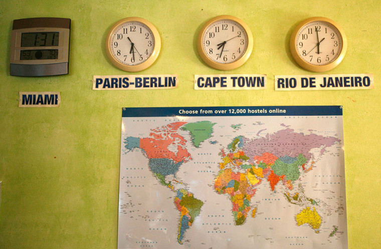 A map and clocks are displayed by the front desk of the South Beach Hostel on Miami Beach, Fla. Wednesday, April 23, 2008, showing the world-wide locations of hostels and different time zones for travelers. (AP Photo/J. Pat Carter)