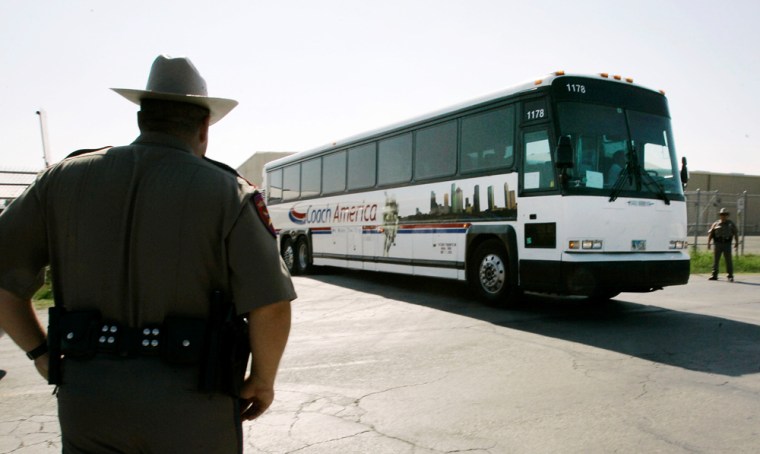 Image: Texas State Troopers, left, and far right,  man a roadblock as a bus with members from the Fundamentalist Church of Jesus Christ of Latter Day Saints