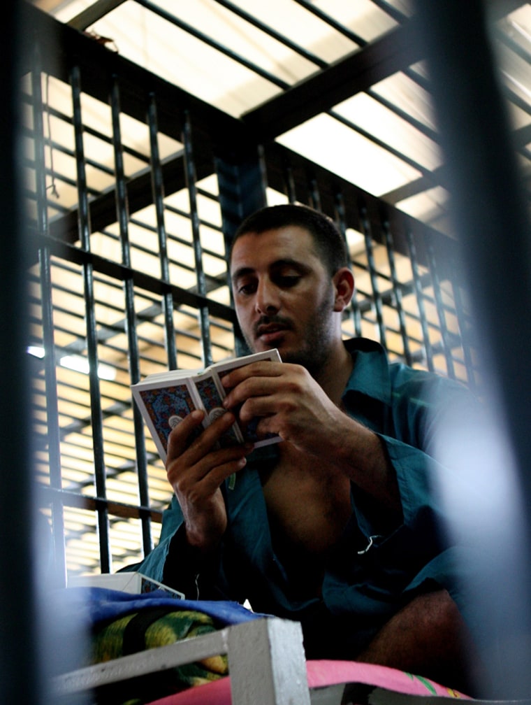 **FILE** In this Aug. 26, 2007 file photo, a prisoner reads Koran inside of his cell in the Rusafa 5 intake prison inside the new judicial Green Zone in Baghdad, Iraq . The amnesty rulings could offer an early exit for many of the 27,000 prisoners in Iraqi hands. They also could wipe the slate for hundreds of the roughly 22,000 detainees held by the U.S. military. (AP Photo/Khalid Mohammed, file)