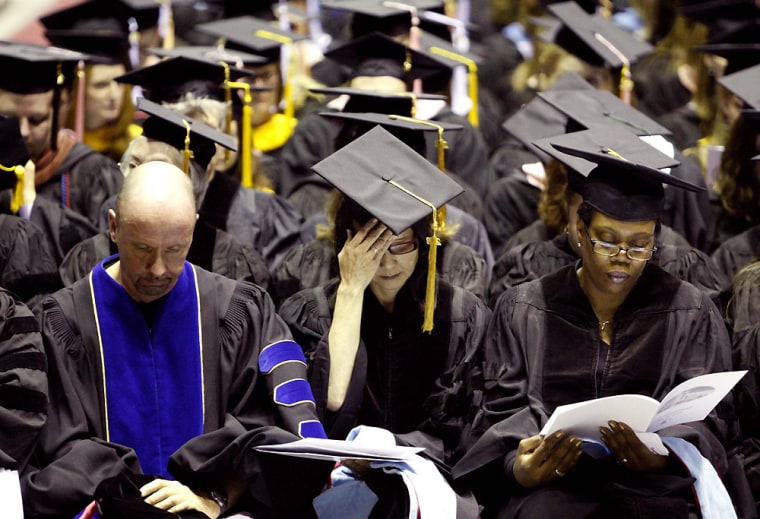 Image: Members of the graduating class of 2008 at Northern Illinois University bow their heads during a moment of silence for those slain during the Feb. 14, 2008 shootings on campus