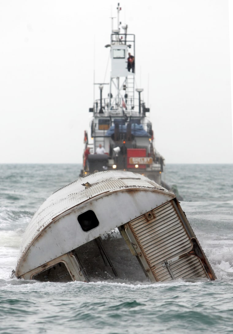 Image: A retired New York City subway carriage is dropped into the Atlantic Ocean to create an artificial reef near the coast Of Ocean City