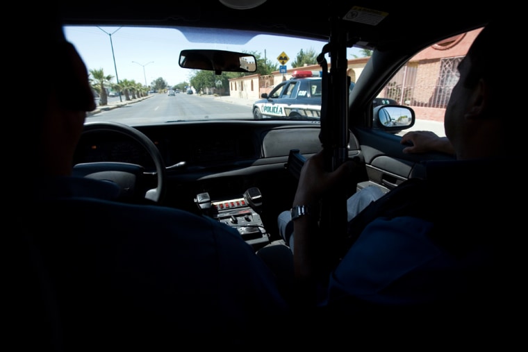 Municipal police officers patrol in a convoy in Ciudad Juarez, Mexico, Wednesday, May 14, 2008. Local police have been given assault rifles and instructed not to patrol the streets alone, after receiving death threats from drug cartels over their own radio frequencies. (AP Photo/Alexandre Meneghini)