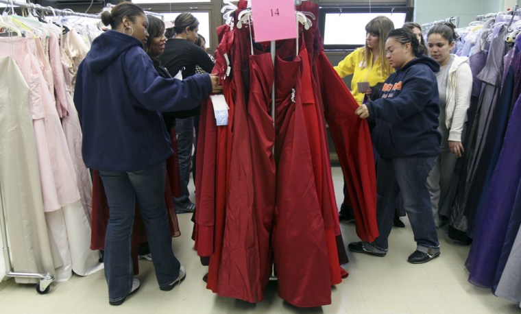 Image: Volunteers and students browse through racks of recycled prom dresses