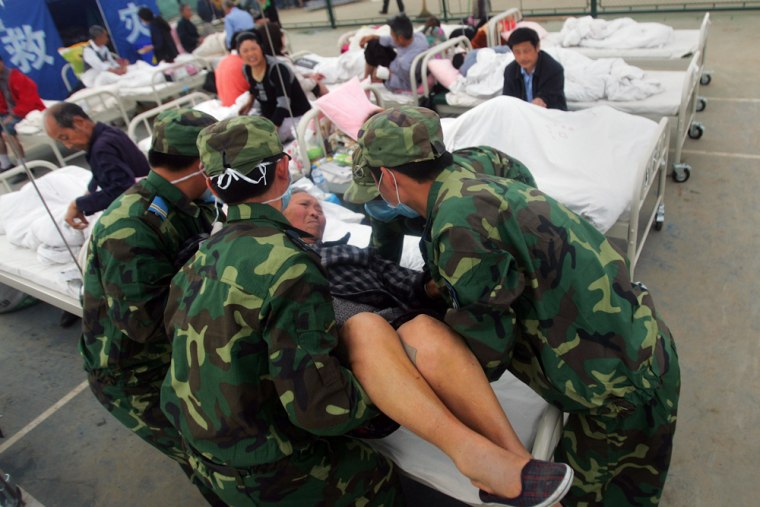 Image: Chinese soldiers lift an earthquake survivor