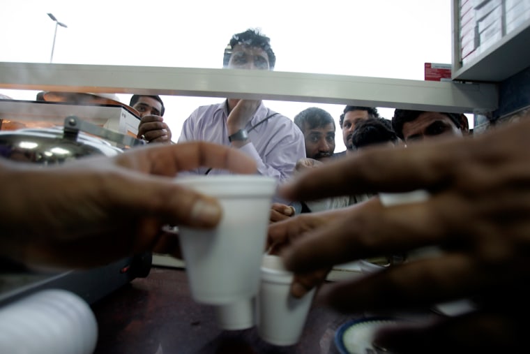 ** FOR STORY SLUGGED DUBAI TRABAJADORES **  Laborers buy tea at a tea shop next to their camps during a weekend in Dubai, United Arab Emirates, Feb. 22, 2008. Dubai's astonishing building boom, which has made it one of the world's fastest-growing cities, has been fueled by the labor of about 700,000 immigrants _ almost all from poor, rural villages in India, Pakistan and Sri Lanka. (AP Photo/Kamran Jebreili)