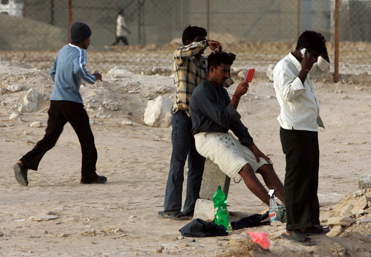 ** FOR STORY SLUGGED DUBAI TRABAJADORES ** An Indian laborer cuts the hair of his friend at a labor camp in Dubai, United Arab Emirates, Feb. 22, 2008. Dubai's astonishing building boom, which has made it one of the world's fastest-growing cities, has been fueled by the labor of about 700,000 immigrants _ almost all from poor, rural villages in India, Pakistan and Sri Lanka. (AP Photo/Kamran Jebreili)