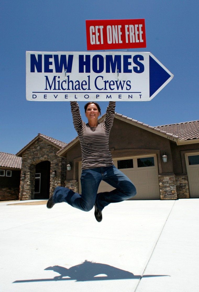 Dawn Berry of Michael Crews Developments jumps for a photographer in front of a 1.8 million-dollar home at a development in San Pasqual Valley