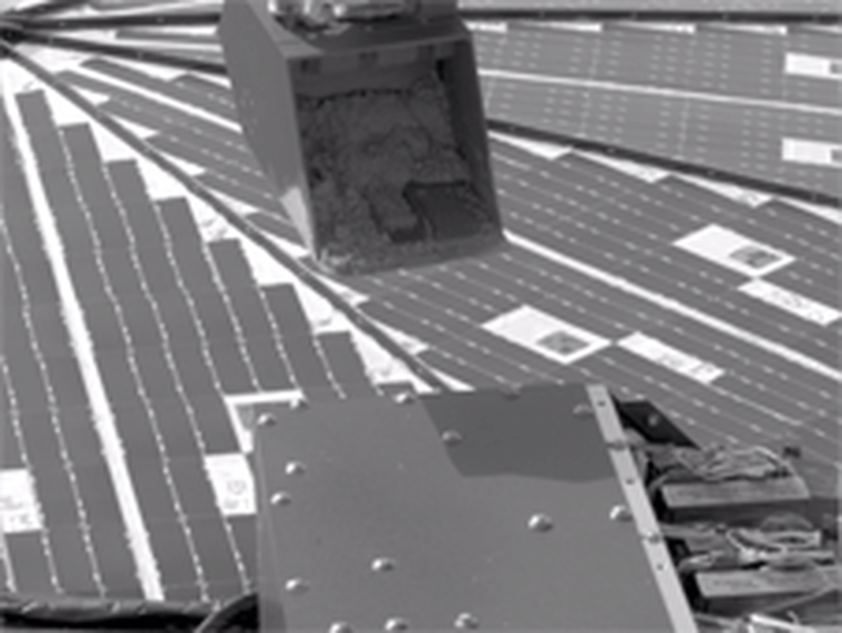 An animated image shows the robotic scoop on NASA's Phoenix Mars Lander sprinkling Martian soil on a test area.