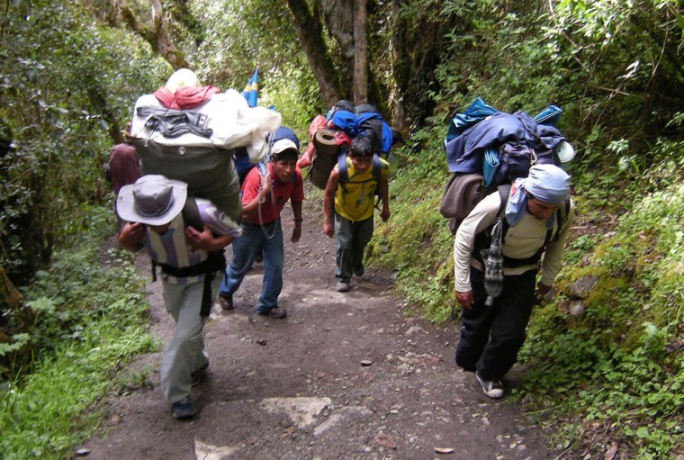 Image: Porters walk along a path during an Inca trail expedition in Cuzco, Peru