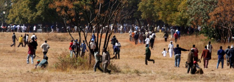 Members of Zimbabwe's ruling Zimbabwe party members, some of them armed with sticks and stones, occupy the venue of a rally planned by the Movement for Democratic Change rally in Harare on Sunday. 