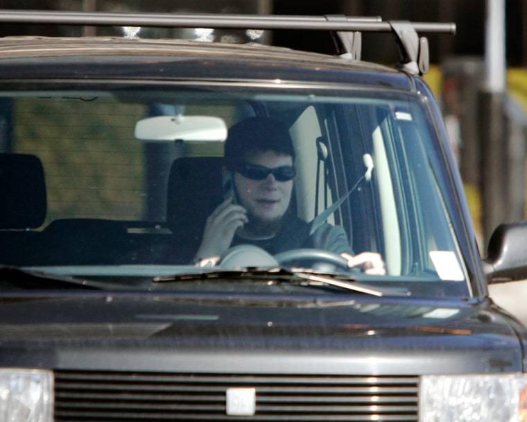 Image: A driver talks on a cell phone while driving