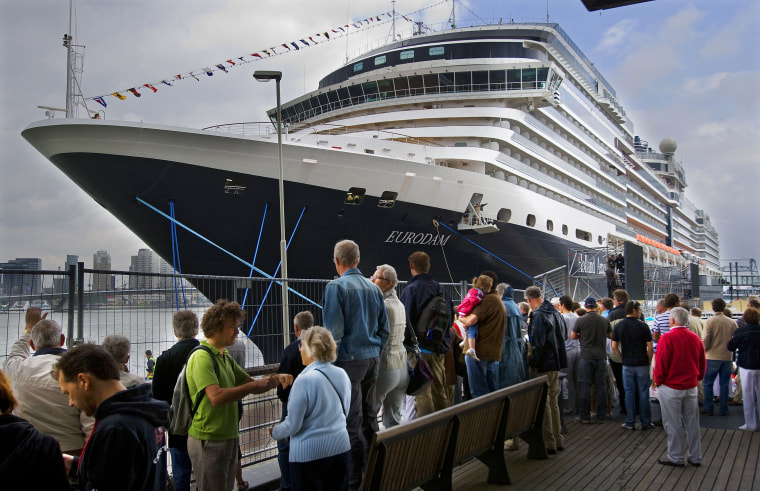 Image: People watch the arrival of the Signature class cruise ship MS Eurodam