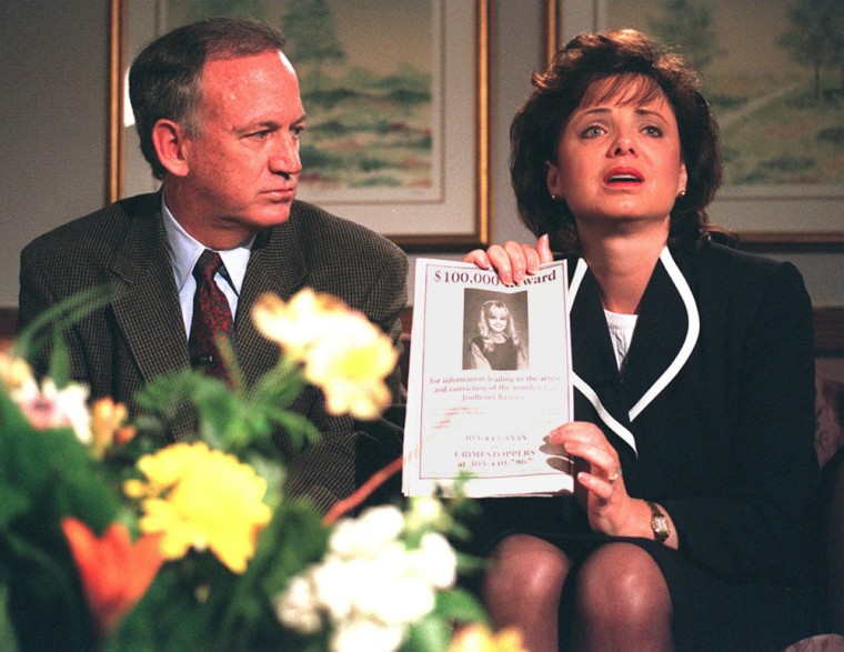 John Ramsey looks on as his wife Patricia holds up