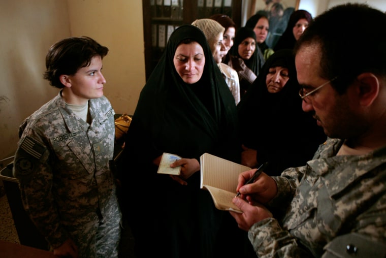 U.S. Army 2nd Lt. Rachel Roberts, left, from Charlie Battery, Fires Squadron, Second Stryker Cavalry Regiment, and a translator, right, enlist Daughters of Iraq security volunteers in al-Abara, north of Baghdad in Iraq's volatile Diyala province on Sunday, July 13, 2008. Around 70 women clad in black abayas fanned themselves in a courtyard at a police station Sunday as Iraqi officials and U.S. troops gathered to celebrate the graduation of the first Daughters of Iraq group in this volatile area. (AP Photo/Maya Alleruzzo)