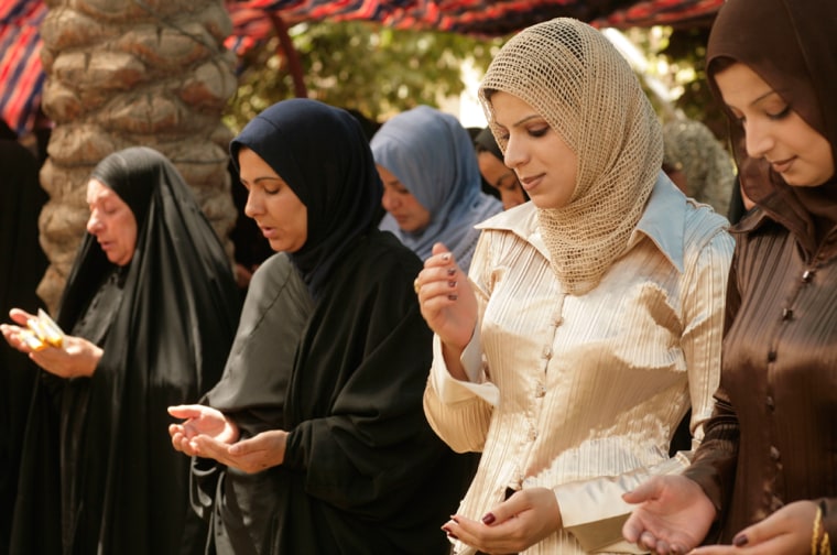 The first class of Daughters Of Iraq pray during their graduation ceremony after training as security volunteers in al-Abara, north of Baghdad in Iraq's volatile Diyala province on Sunday, July 13, 2008. Around 70 women clad in black abayas fanned themselves in a courtyard at a police station Sunday as Iraqi officials and U.S. troops gathered to celebrate the graduation of the first Daughters of Iraq group in this volatile area. (AP Photo/Maya Alleruzzo)