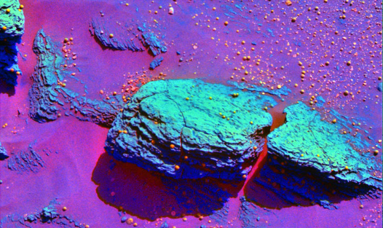 A false-color, infrared image of the rock formerly known as Snout shows the different composition of the bedrock (green) and the blueberry-style spherules (orange) near the Opportunity rover. Some spherules can be seen adhering to the rock, which is now known as Stone Mountain.