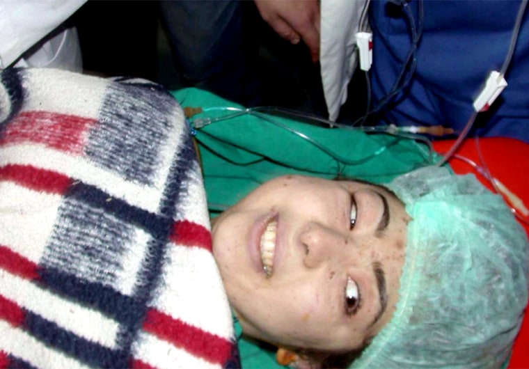 Turkish woman, 24-year old Yasemin Yaprakci smiles in an ambulance after she was pulled out alive from the rubble of a collapsed apartment building in Konya, central Turkey, Monday, Feb. 9, 2004, seven days after the building collapsed.   Rescue workers spent hours working to free her feet which were trapped under bodies. Her condition is reported to be serious. (AP Photo/Bostan Cemiloglu/Cihan) ** TURKEY OUT **