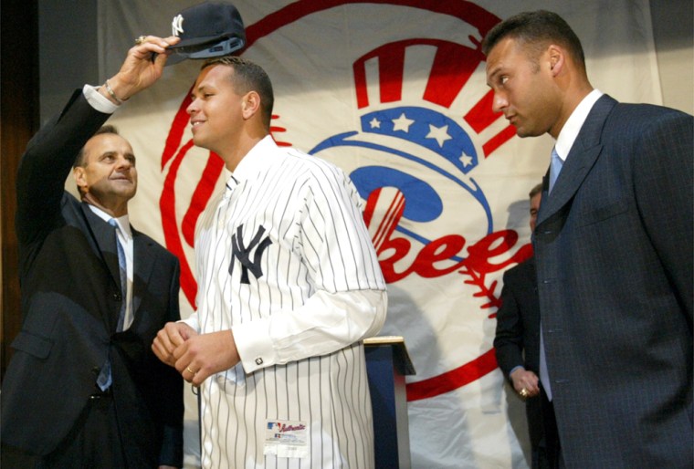 New York Yankees skipper Joe Torre puts a New York Yankees cap on the newest member of the team, Alex Rodriguez, center, as teammate Derek Jeter looks on at a news conference at Yankee Stadium in New York Tuesday, Feb. 17, 2004. The Yankees introduced their newest highly paid All-Star a day after commissioner Bud Selig approved the trade moving Rodriguez from the Texas Rangers to the Bronx. (AP Photo/Gregory Bull)