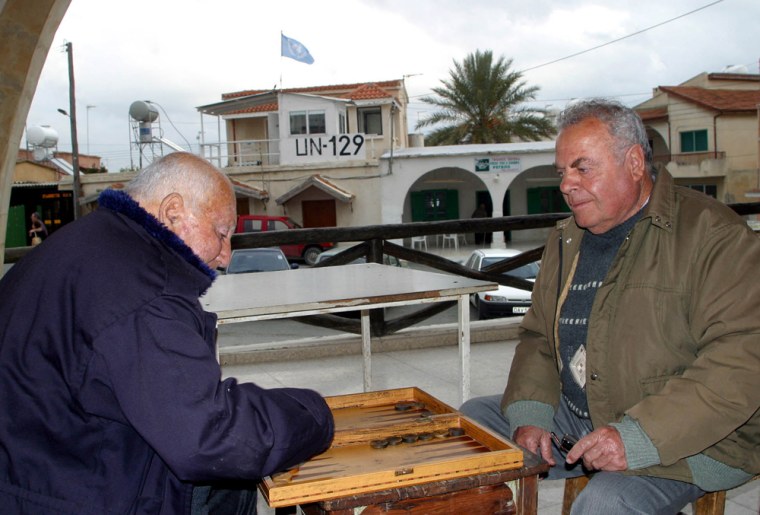 Turkish Cypriot men play backgammon at a coffee shop in the town of Pyla, Cyprus, Tuesday Feb. 17, 2004. The town of Pyla, the only major mixed Turkish-Greek town on the divided island, could soon become a role model if Cyprus is unified. But the town is also a symbol of the difficulties that the future of Cyprus holds, a town where many ethnic Turks and Greeks maintain peace by going to separate schools, coffee clubs and stores and having little to do with each other. Greek and Turkish Cypriot leaderswill meet Thursday for a high-pressure round of peace talks aimed at reunifying the island. (AP Photo/Harun Ucar)
