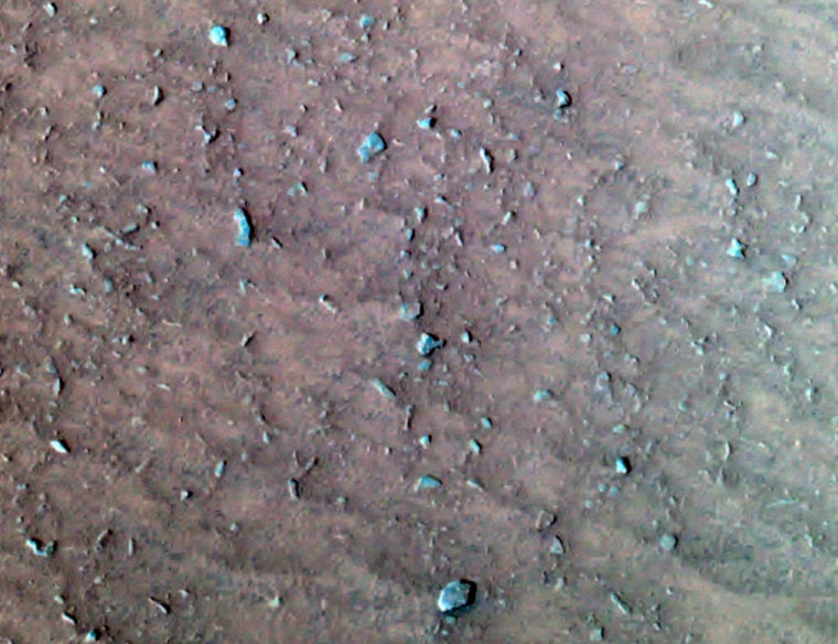 A color composite image from NASA's Spirit rover shows the rocks and dirt surrounding the probe in an area dubbed "Laguna Hollow." Scientists are intrigued by the clustering of small pebbles and the cracklike fine lines, which indicate a coherent surface that expands and contracts.