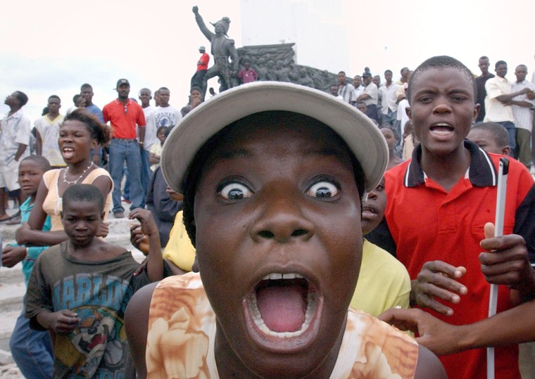 A woman shouts in front of the Heroes Monument as she participates in rebel rally in Gonaives on Thursday.