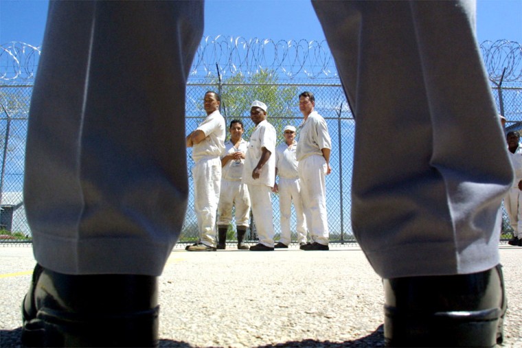 A guard watches as inmates prepare for a work detail at the minimum-security facility known as the Carol Vance Unit.