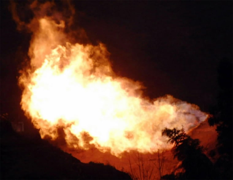 FIRE POURS OUT OF THE MOUTH OF A NATURAL GAS WELL IN CHINA'S SOUTHWESTERN MUNICIPALITY OF CHONGQING