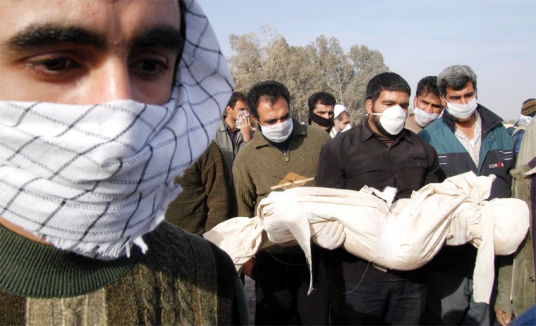 Image: Men carry body of quake victim for burial