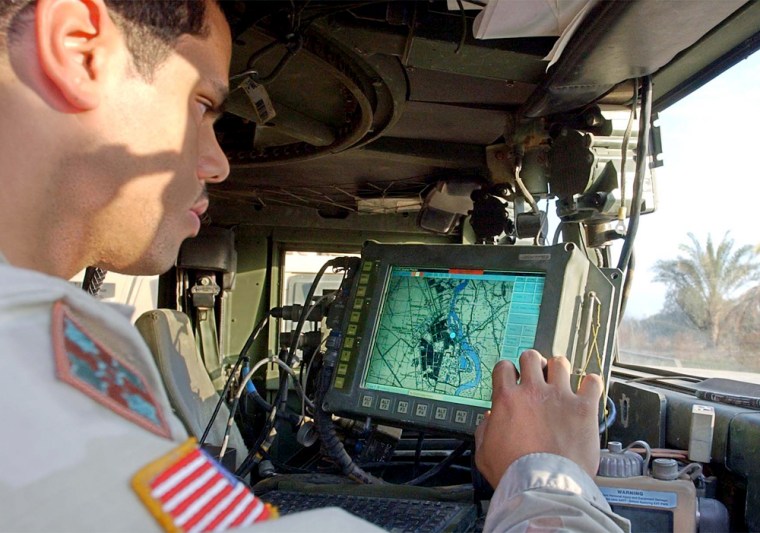 U.S. Army Spc. Michael Scott, from Michigan, of the 1st Battalion 22nd Regiment 4th infantry division, sitting inside his humvee checks a map on a computer screen, in Tikrit, Iraq, Wednesday, Dec. 31, 2003.
