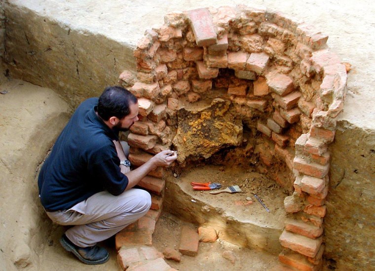Michael Lavin, curator at APVA Preservation Virginia, excavates an intact breastplate from the inside wall of the well at the historic Jamestown site.