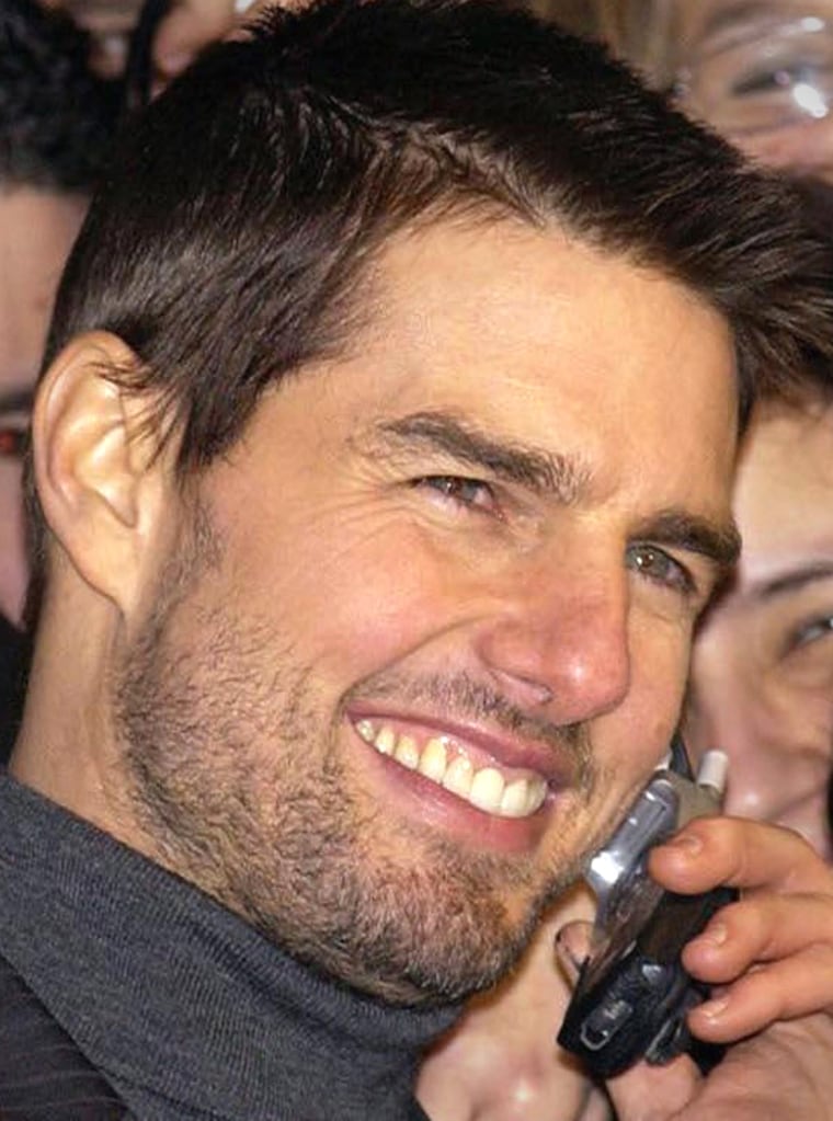 Actor Tom Cruise talks to fans and poses for photos as he arrives for the British premiere of his latest film