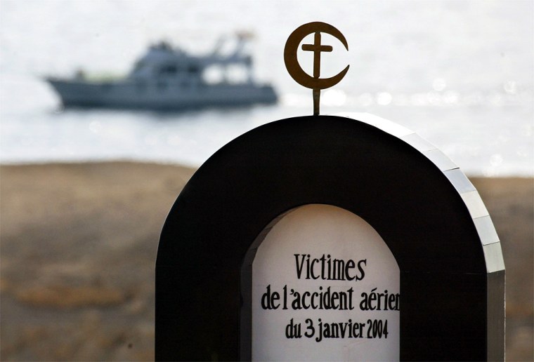 A tourist boat passes a monument dedicated to the victims of an Egyptian charter airplane crash during a memorial service on a hillside in the Red Sea resort city of Sharm el-Sheik, Egypt, Thursday, Jan. 8, 2004. Relatives gathered to honor the 148 victims who died when the plane crashed into the Red Sea early Saturday. (AP Photo/Kevin Frayer)