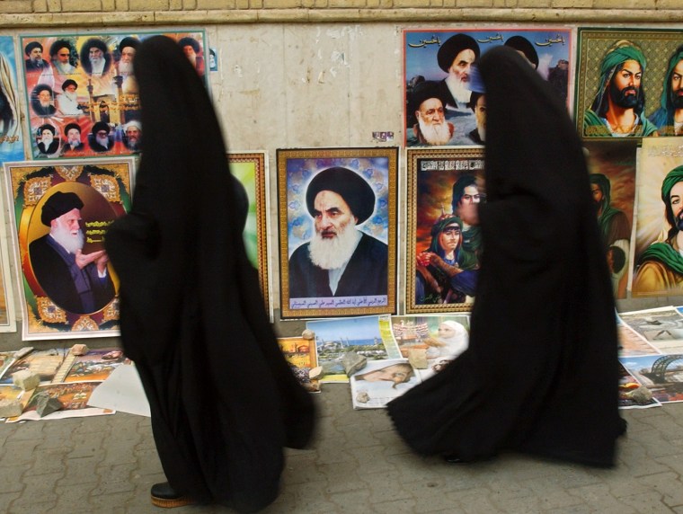 Two Iraqi women walk past a portrait of Grand Ayatollah Ali al-Husseini al-Sistani, center, in Baghdad on Tuesday. Al-Sistani's support for a U.S. transition plan is seen as crucial for its success.